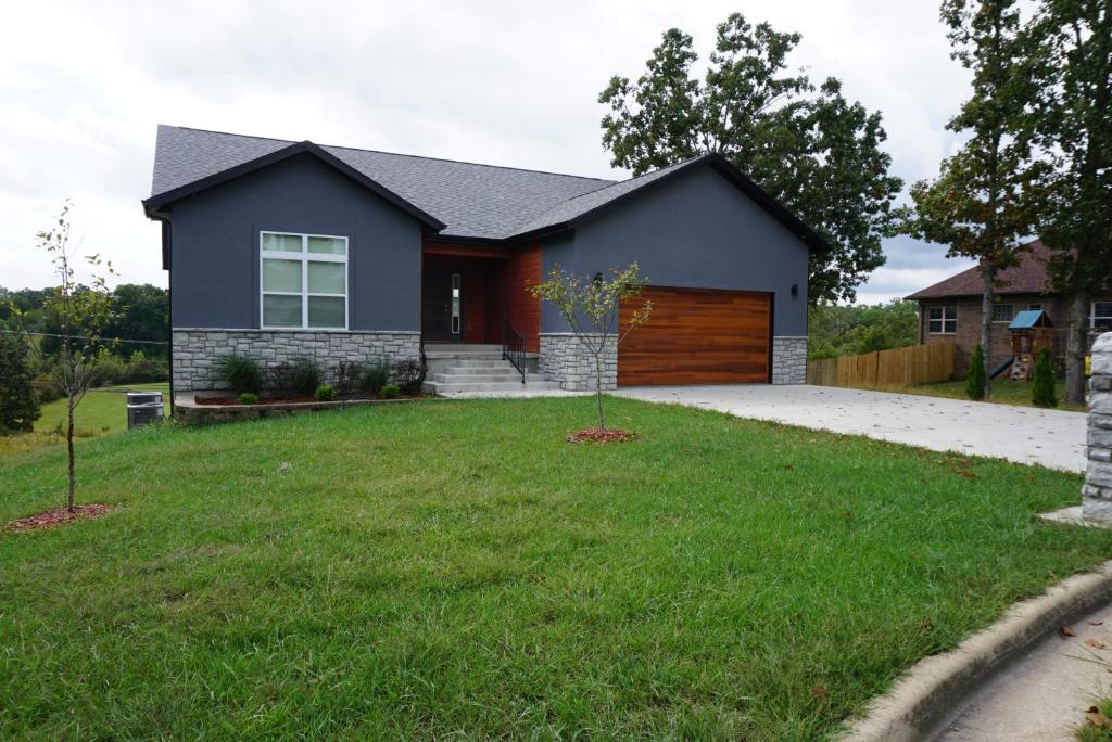 a house with a garage and a grass yard at Hideaway in a Luxurious Location in Saint Robert