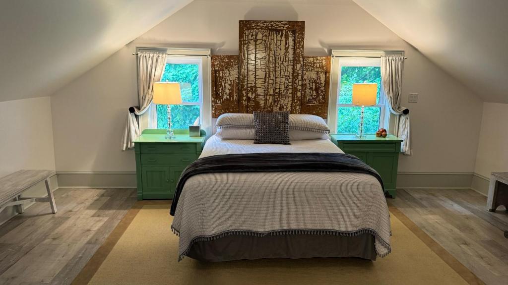 a bedroom with a large bed and two windows at The 1885 Suites in Picton