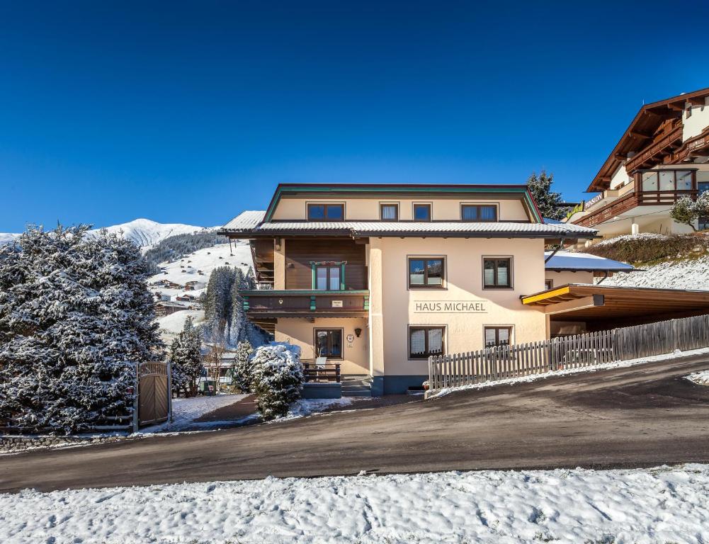 a building in the snow with a road in front at Haus Michael in Tux