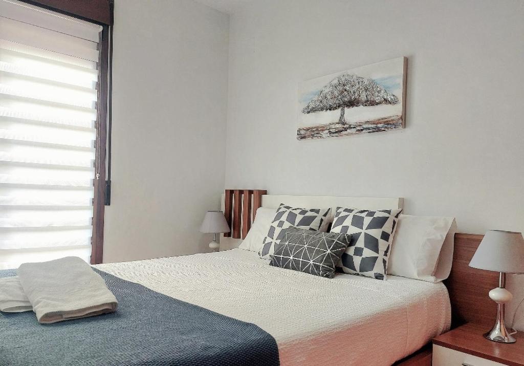 Un dormitorio con una cama y un árbol en la pared. en Apartamento Vive Teruel, en Teruel