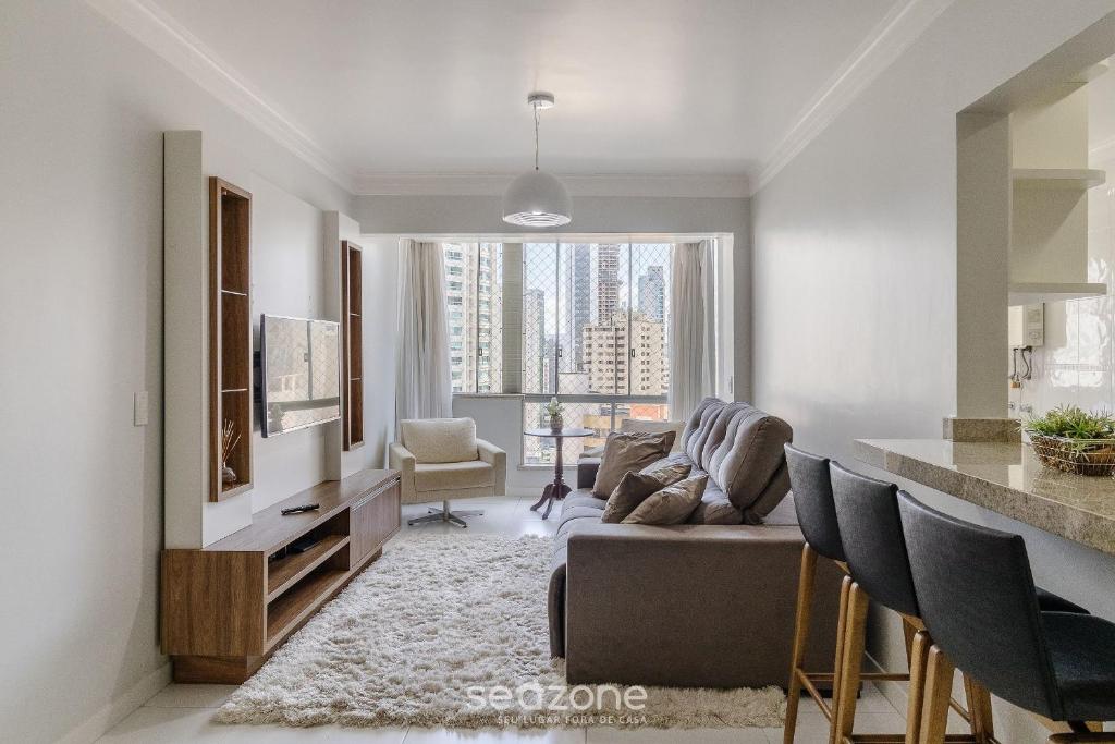 a living room with a couch and a table at Apto vista mar c/ churrasq. na orla BC CET1604 in Balneário Camboriú