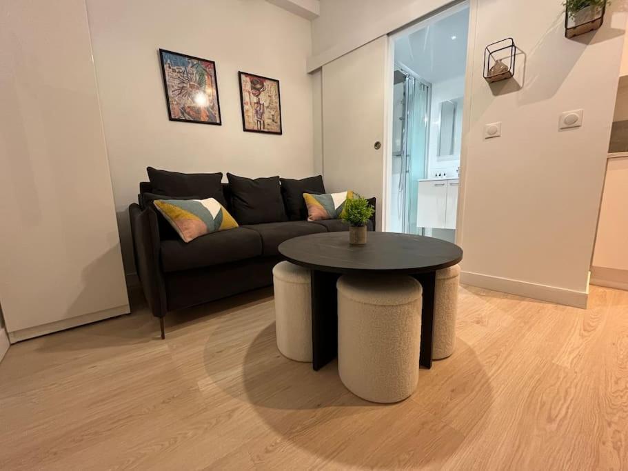 un salon avec un canapé et une table dans l'établissement Oberkampf by Melvane 18, à Paris