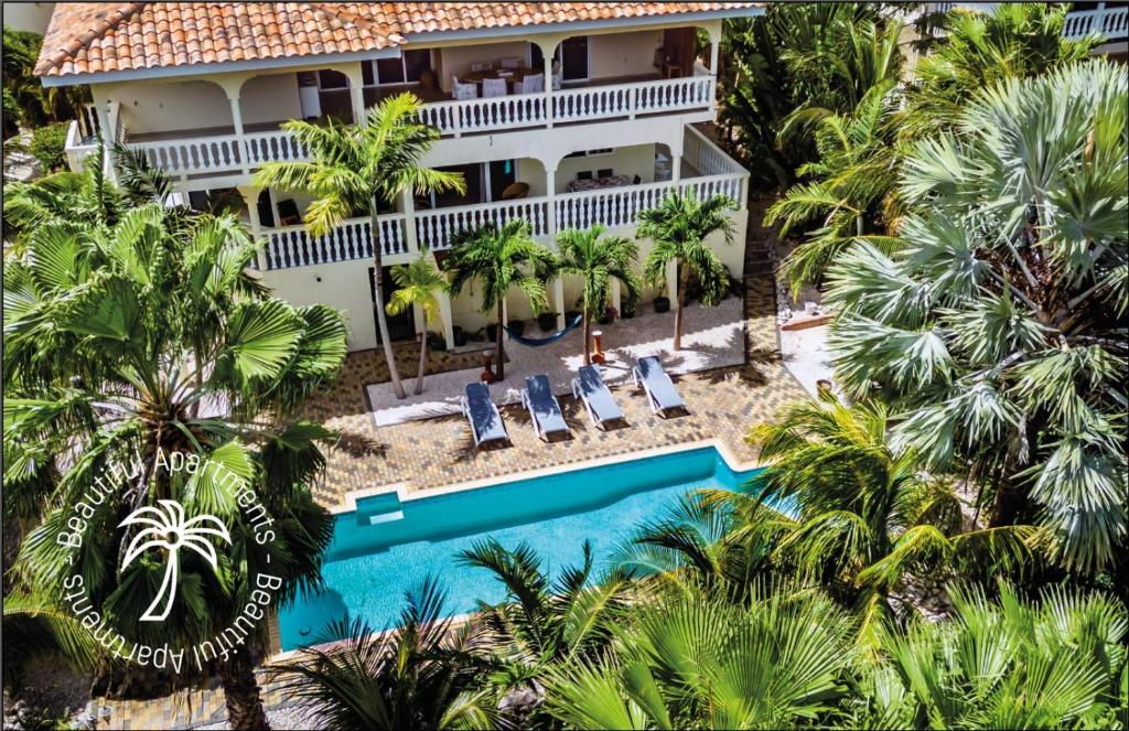 an aerial view of a resort with a pool and palm trees at Droom appartementen in Willemstad