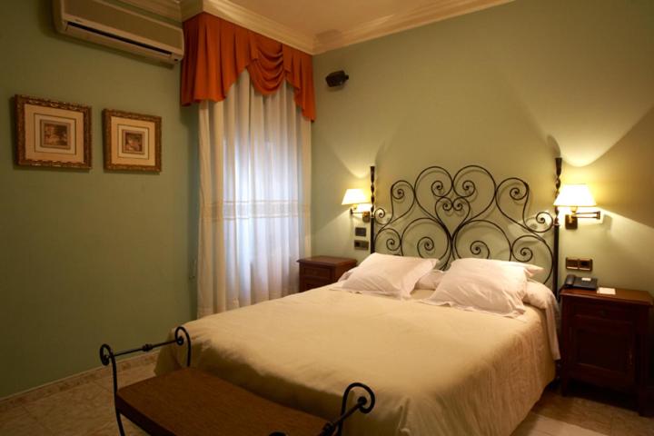 a bedroom with a large white bed with two lamps at Hotel Juanito in La Roda
