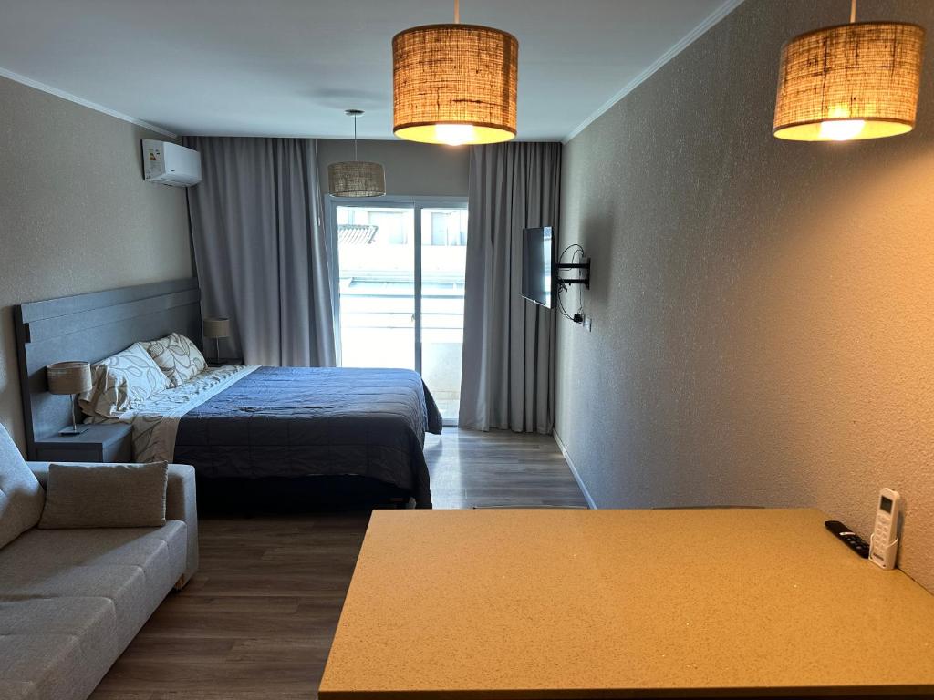 una habitación de hotel con una cama y un sofá en Casa de playa monoambiente, en Necochea