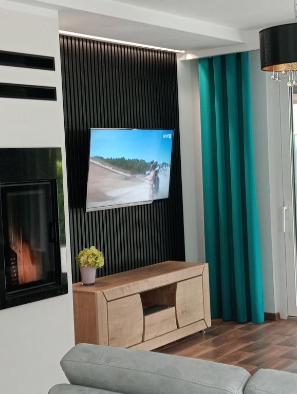 a living room with a couch and a flat screen tv at Willa Piasutno z klimatyzacją in Świętajno
