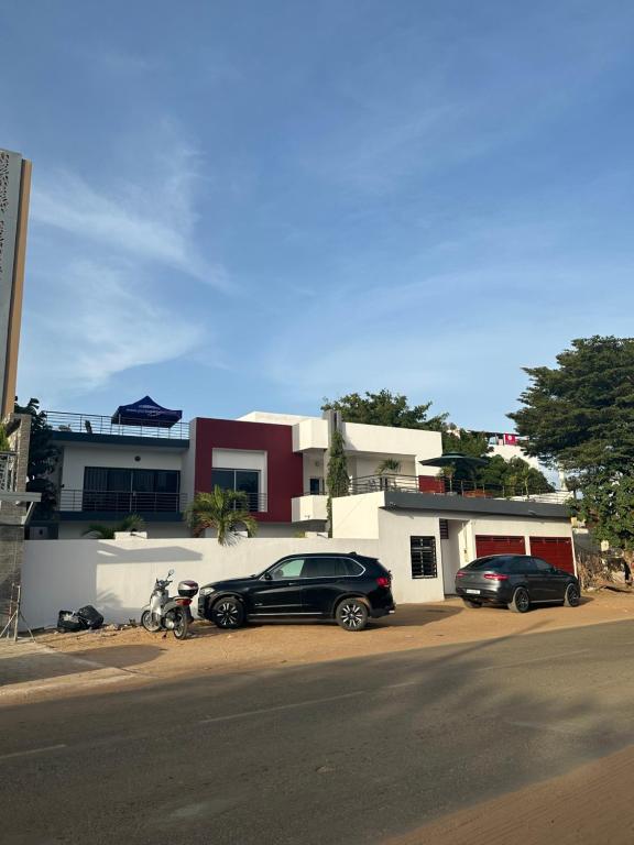due auto parcheggiate davanti a un edificio di Villa Somone a Dakar