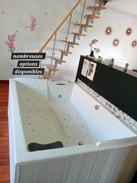 - une grande baignoire dans une chambre avec des escaliers dans l'établissement Ecrin de bien-être proche Viarhôna et Walibi, à Saint-Victor-de-Morestel