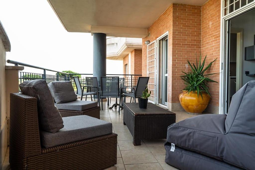 Un patio con sillas y un sofá en un balcón. en Residenza dell Agrifoglio, en Mostacciano