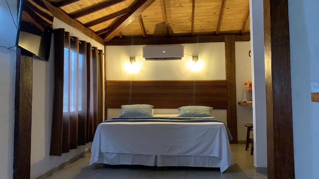 Schlafzimmer mit einem Bett mit Holzdecke in der Unterkunft Loft Teto Muriquis in Nova Lima