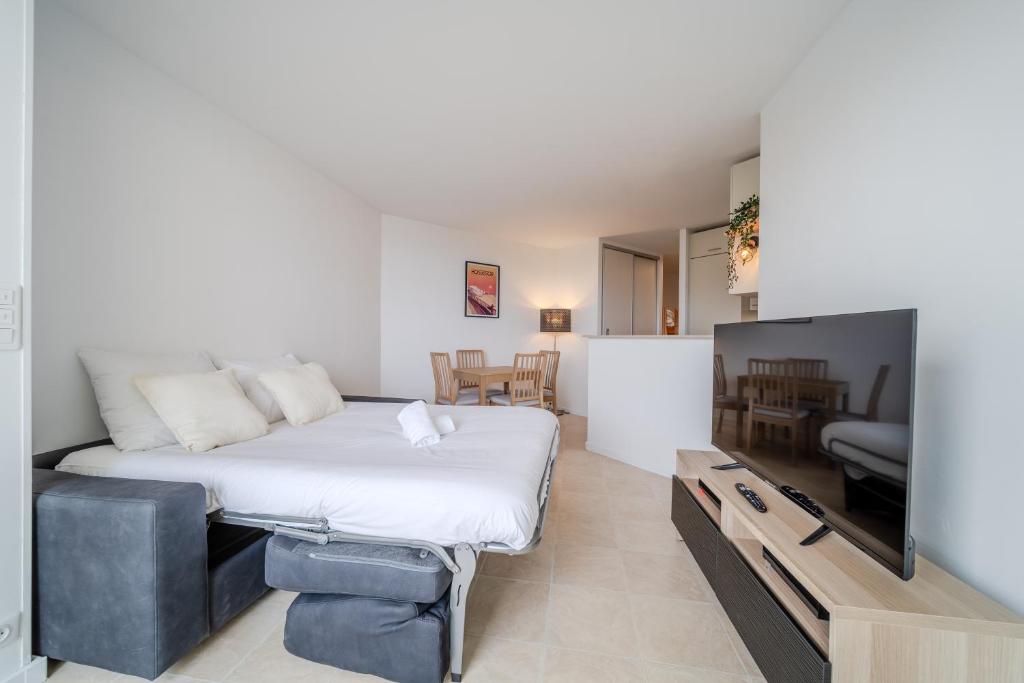 Un dormitorio con una cama y un televisor de pantalla plana. en Atlantic Selection - Vue Océan - La Sud Hossegor, en Soorts-Hossegor