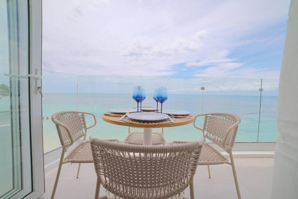a table with four chairs and blue glasses on it at DelMare At Buye Beach Rooftop in El Cerro