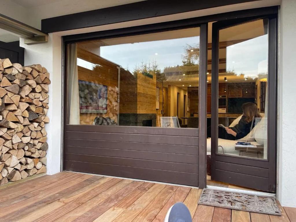 ムジェーヴにあるAppartement chaleureux à Megève - 80 m² avec jardin et cheminée.の木材の山が積まれた家の引き戸