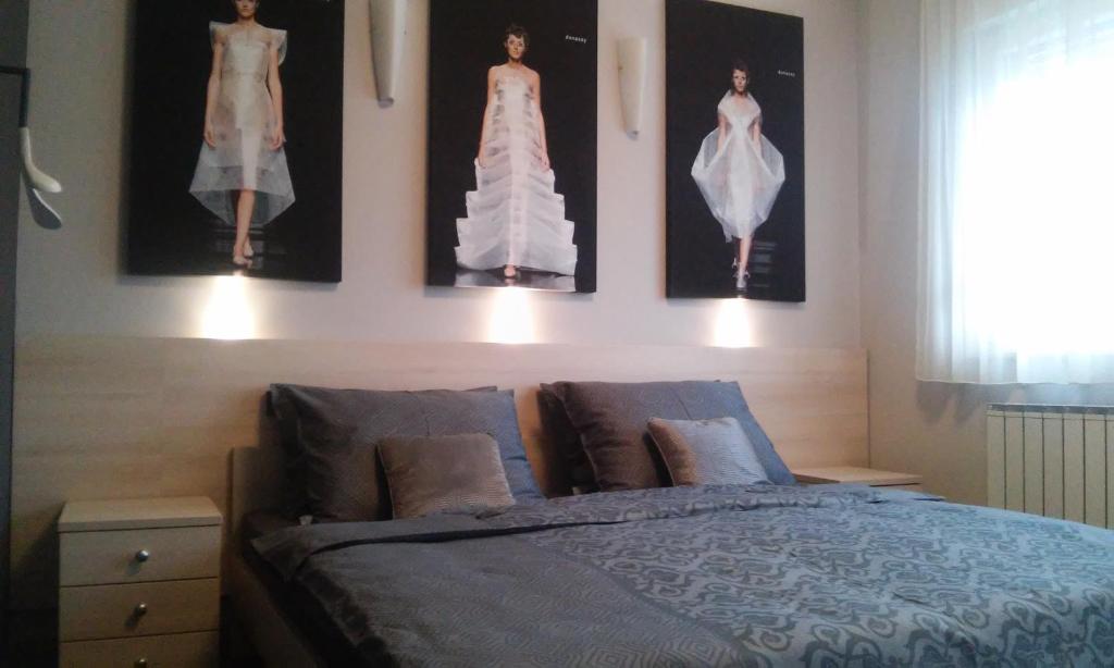 a bedroom with a bed with pictures on the wall at Zagreb Lodge Apartment in Zagreb