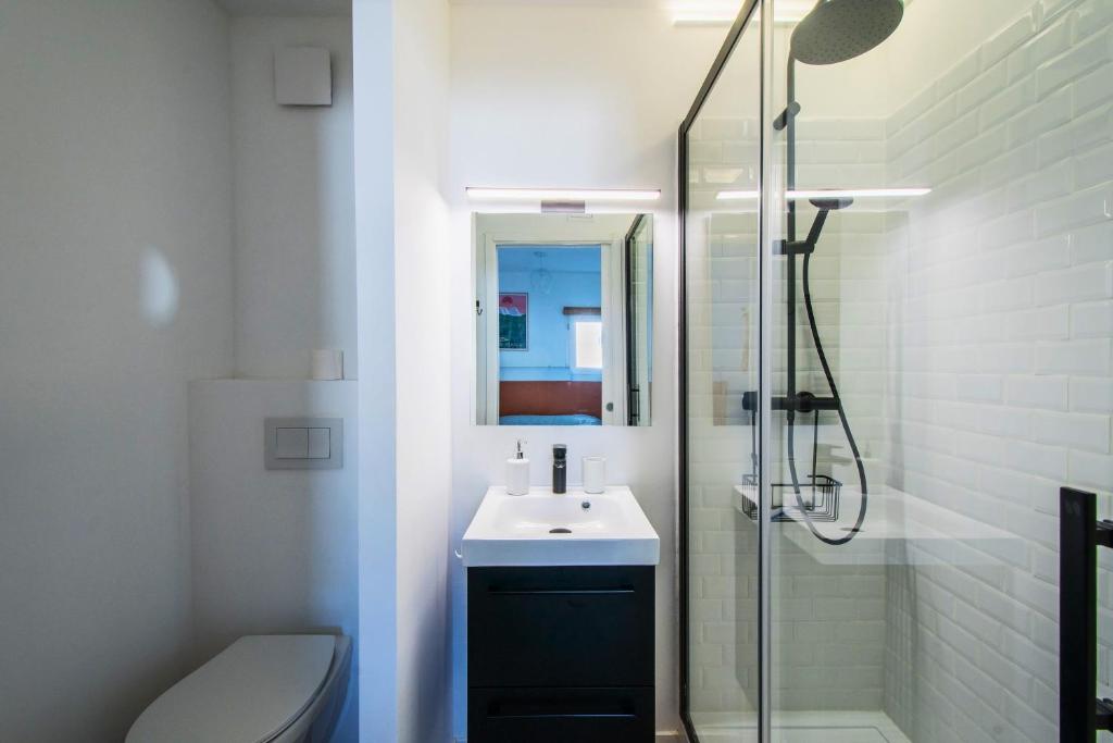 Un baño con lavabo y ducha de cristal. en T2 - Terrasse - 3 min à pieds des plages- Parking privée - Clim - Wifi - 4 PAX, en La Grande-Motte