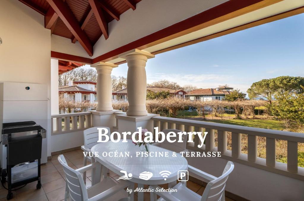 een balkon met een tafel en stoelen en een grill bij Atlantic Selection - Domaine de Bordaberry - Avec piscine et vue océan in Urrugne