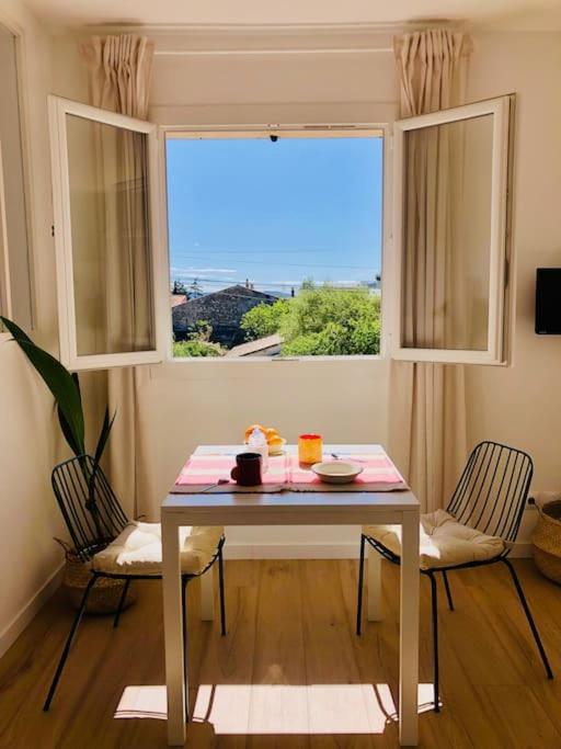 une table et deux chaises dans une pièce avec une fenêtre dans l'établissement Lou Pitchou, le T1, à La Ciotat