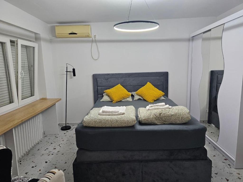 Un dormitorio con una cama azul con almohadas amarillas en Apartment Ivon, en Belgrado