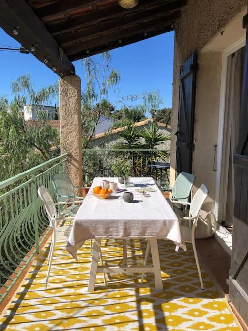 d'un balcon avec une table et des chaises blanches. dans l'établissement Lou Niú - le T3, à La Ciotat