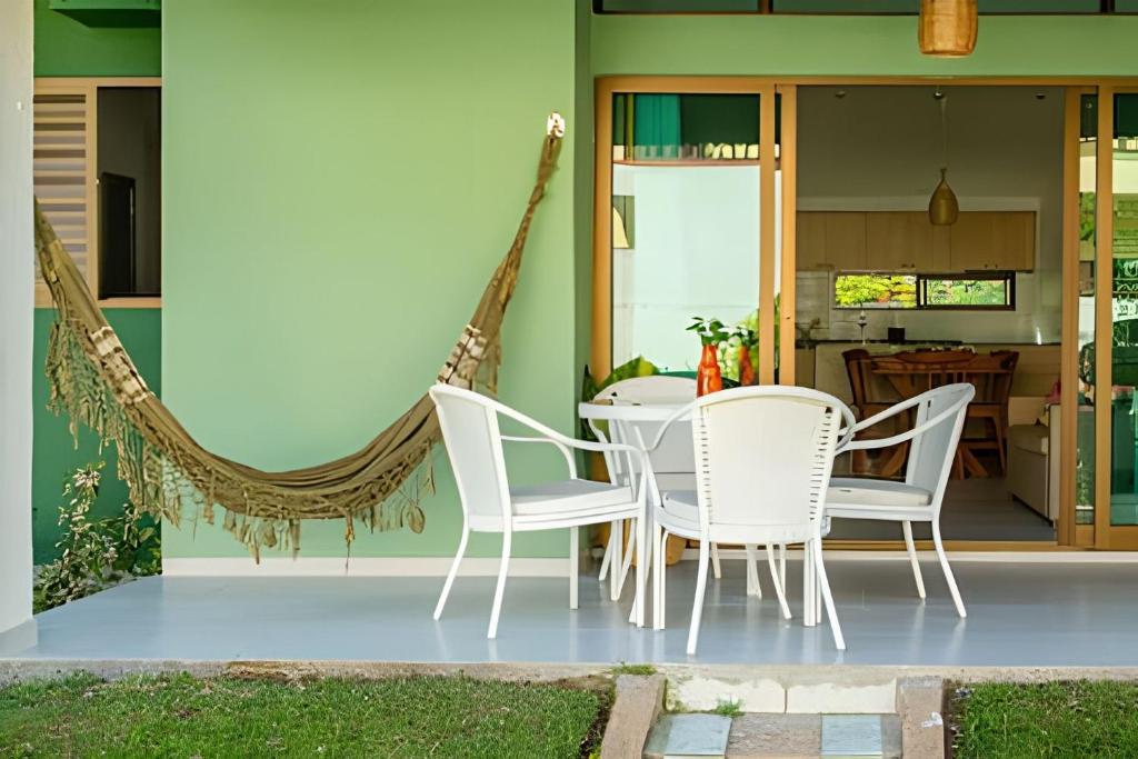 ポルト・デ・ガリーニャスにあるLC Casas de Praia - Chalé 3 centrinho de Portoのパティオ(テーブル、椅子、ハンモック付)