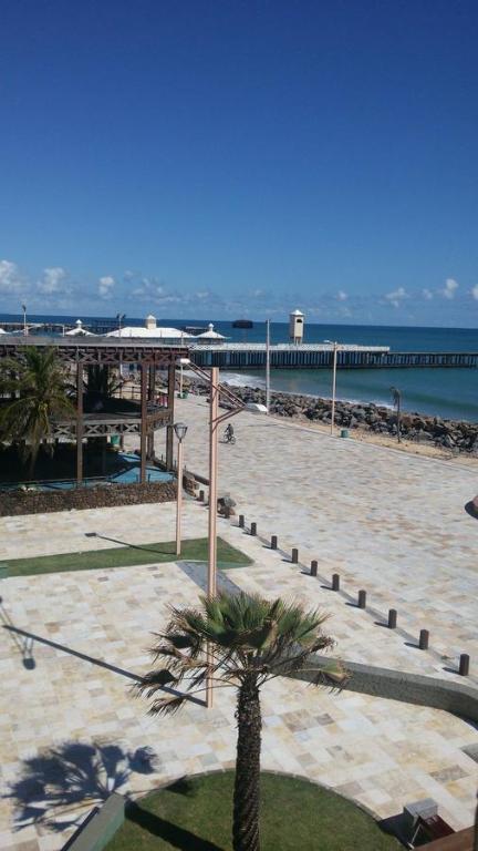 uma praia arenosa com um cais e uma palmeira em Flat na Praia de Iracema 105 em Fortaleza