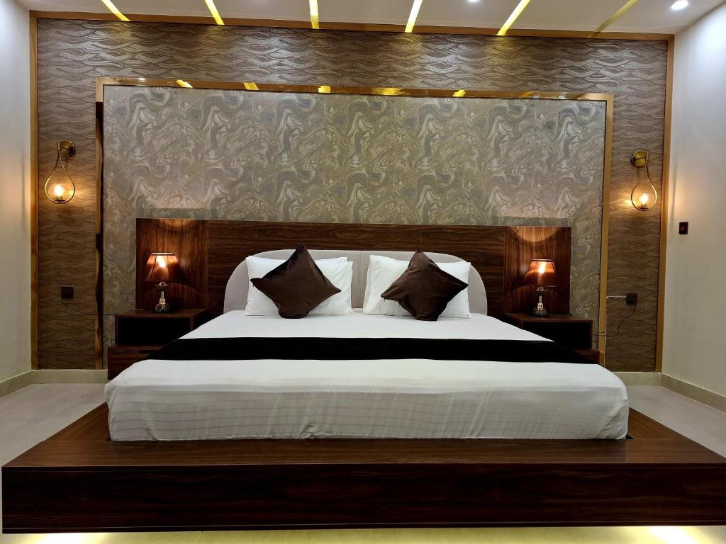 a bedroom with a large bed with a large headboard at Royal Galaxy Hotel & Residence - Near Islamabad International Airport & Motorway in Islamabad