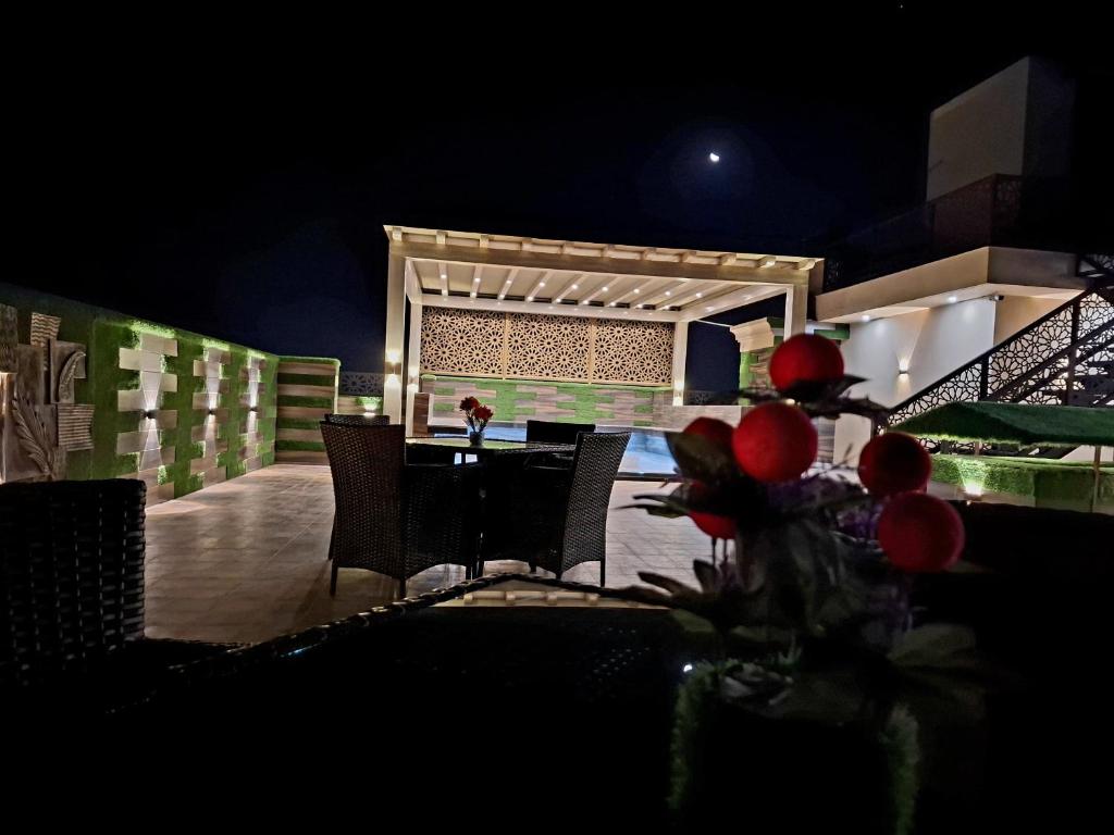 a dining room with a table and chairs at night at Royal Galaxy Hotel & Residence - Near Islamabad International Airport & Motorway in Islamabad