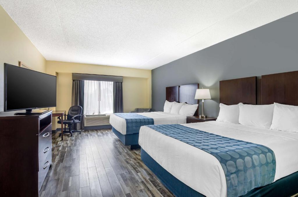 a hotel room with two beds and a flat screen tv at Best Western Plus Waynesboro in Waynesboro