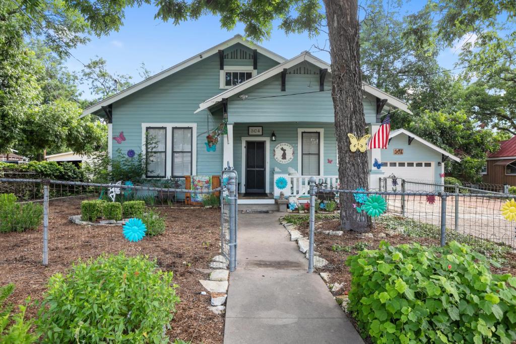 a house with a tree and a sidewalk at Ms. Bunny's Bungalow in Fredericksburg