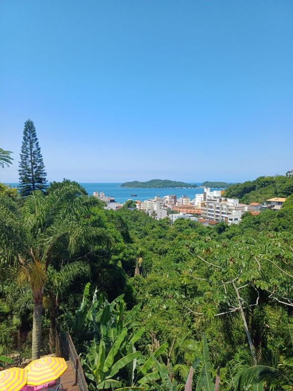 a view of the ocean from a resort with palm trees at Suíte com vista panorâmica in Bombinhas