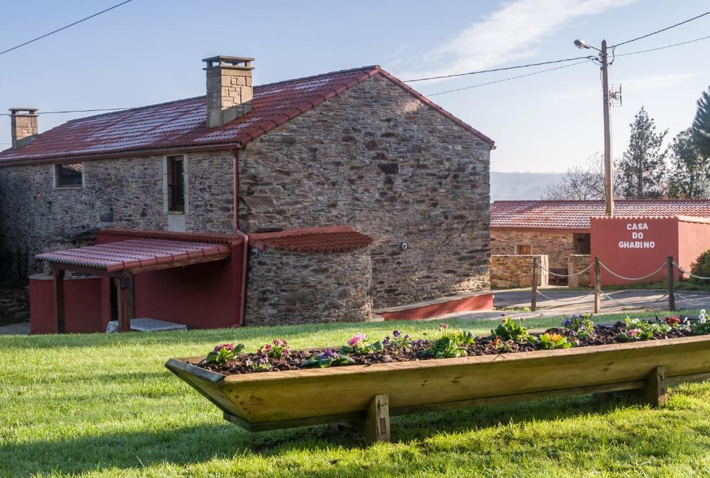 a stone building with a garden in a wooden boat at Casa Do Ghabino in Santa Comba