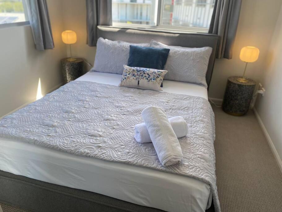 a bedroom with a large bed with towels on it at Good Vibes Only on Stanley in Townsville