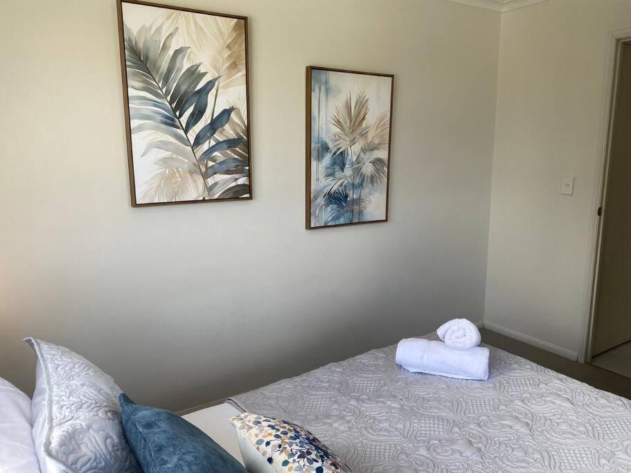 a bedroom with two pictures on the wall and a bed at Good Vibes Only on Stanley in Townsville