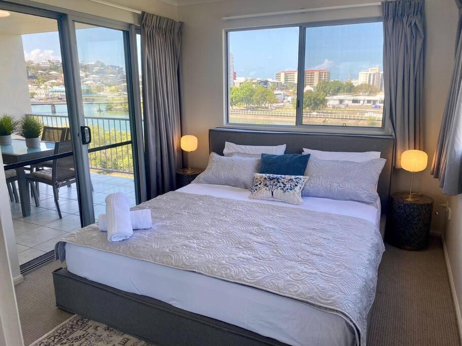 a bedroom with a large bed and a balcony at Good Vibes Only on Stanley in Townsville