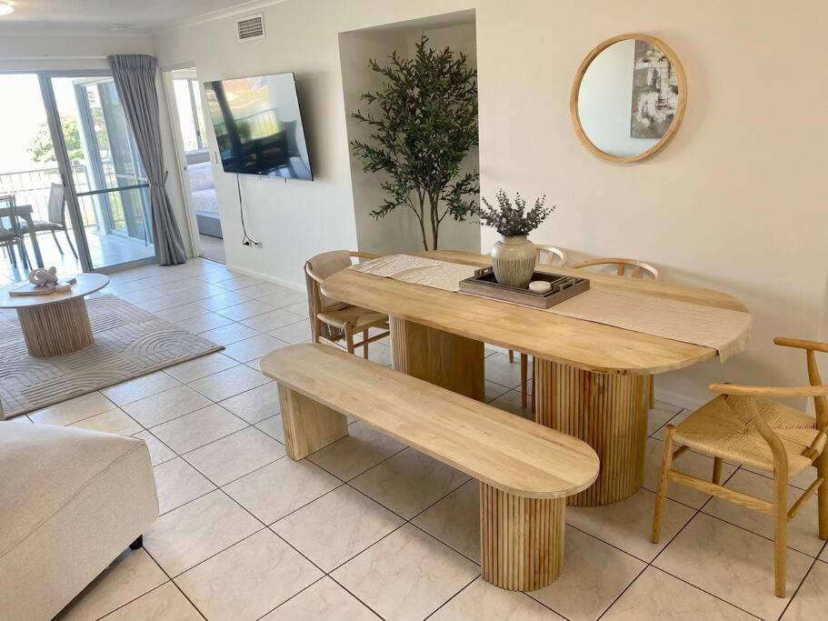 a wooden table and bench in a living room at Good Vibes Only on Stanley in Townsville