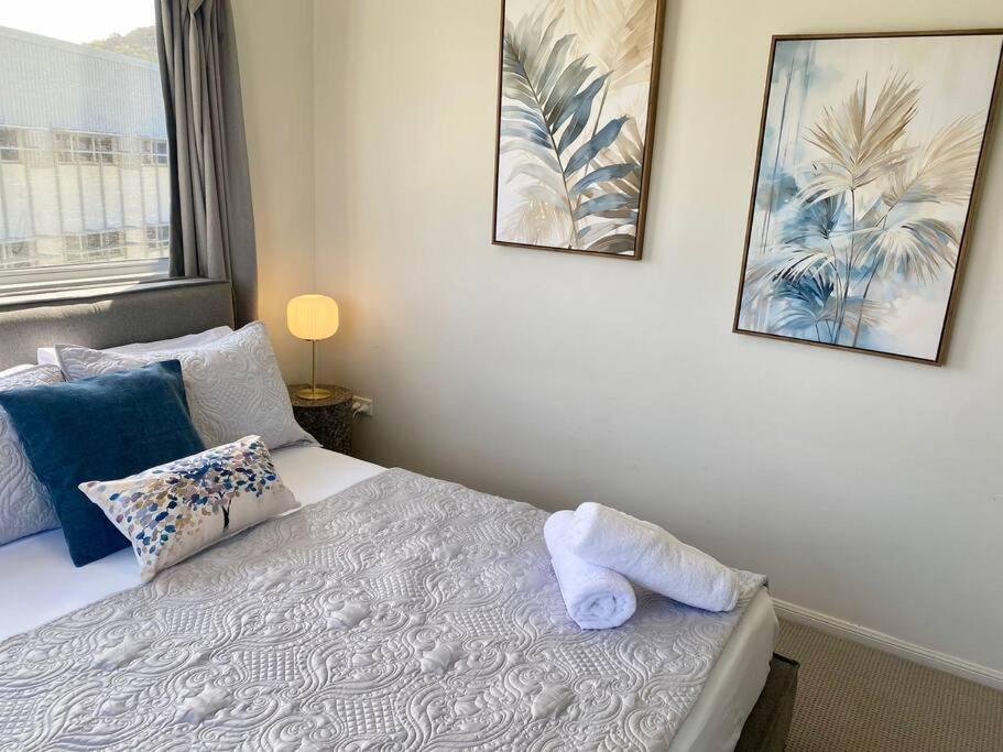 a bedroom with a bed and two pictures on the wall at Good Vibes Only on Stanley in Townsville