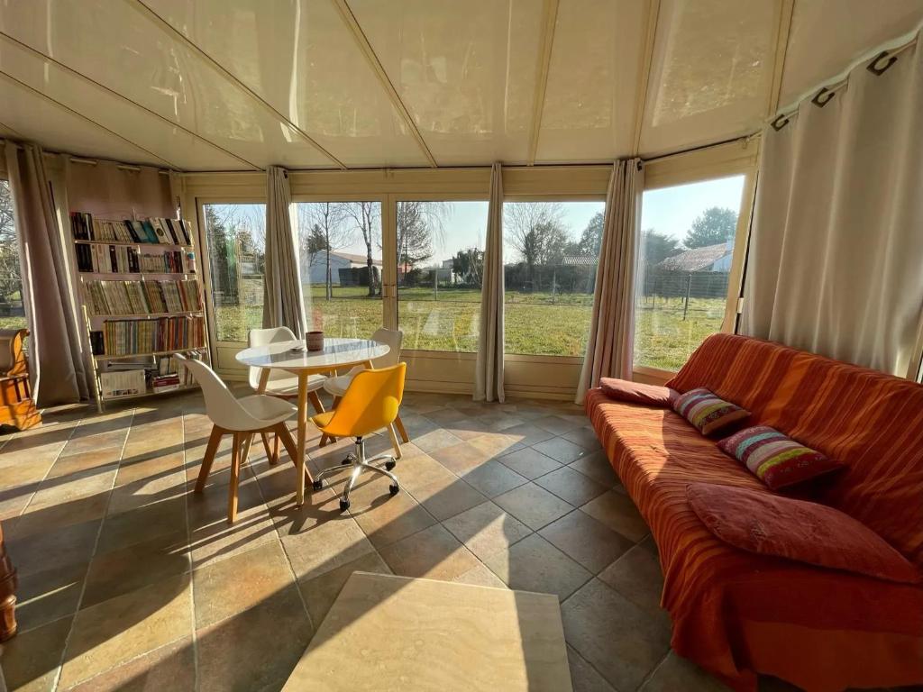 a living room with a couch and a table at Maison accueillante à Gémozac - 100 m² avec jardin fertile. in Gémozac