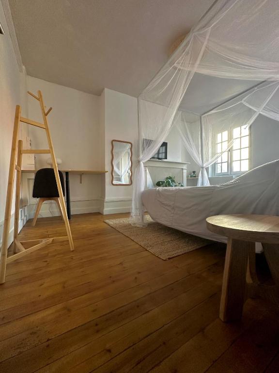 - une chambre avec un lit à baldaquin et du parquet dans l'établissement Le Rêve Cosy, Studio Équipé, à Arras