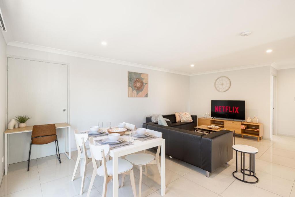 a living room with a table and a couch at Smart Suites Self Check-in Apartments - Rocklea Station S in Brisbane