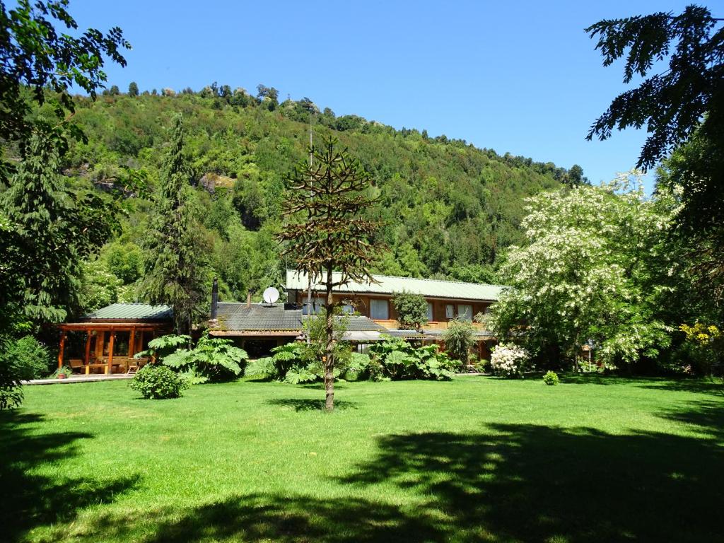 una casa en medio de un patio verde en Espacio y Tiempo Hotel de Montaña en La Junta