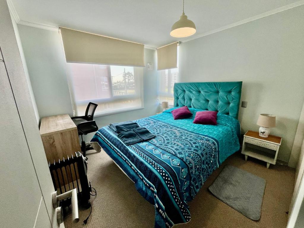 - une chambre avec un lit bleu et des oreillers violets dans l'établissement Depto Maximo en condominio central 3D 1B Parking Excelente Conectividad,Atención Empresas-Facturas, à Chillán
