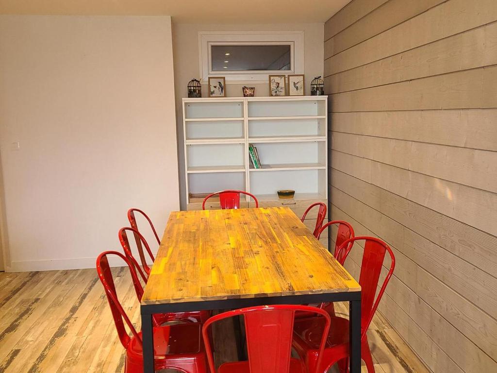 - une table avec des chaises rouges dans l'établissement Appartement 4 pièces rénové - 9 pers, Ascenseur, Balcon, Parking - Pied des pistes - FR-1-689-136, à Villard-de-Lans
