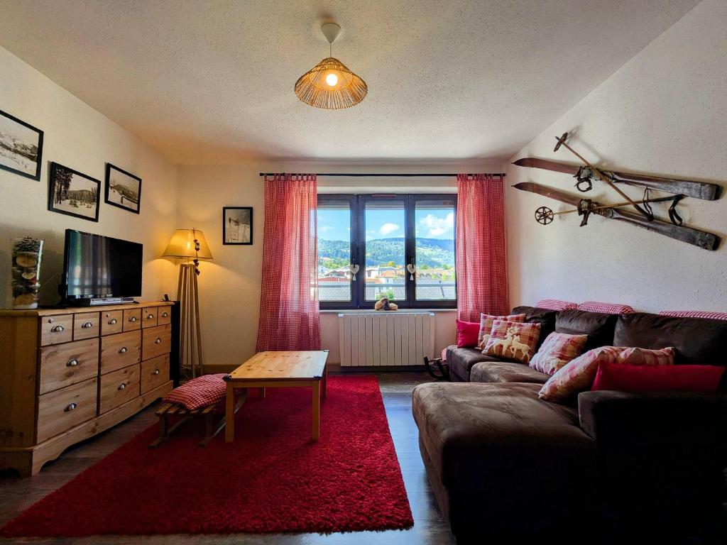 a living room with a couch and a large window at Appartement 2 chambres, max 6 pers, proche des stations, centre-ville Cornimont - FR-1-589-666 in Cornimont