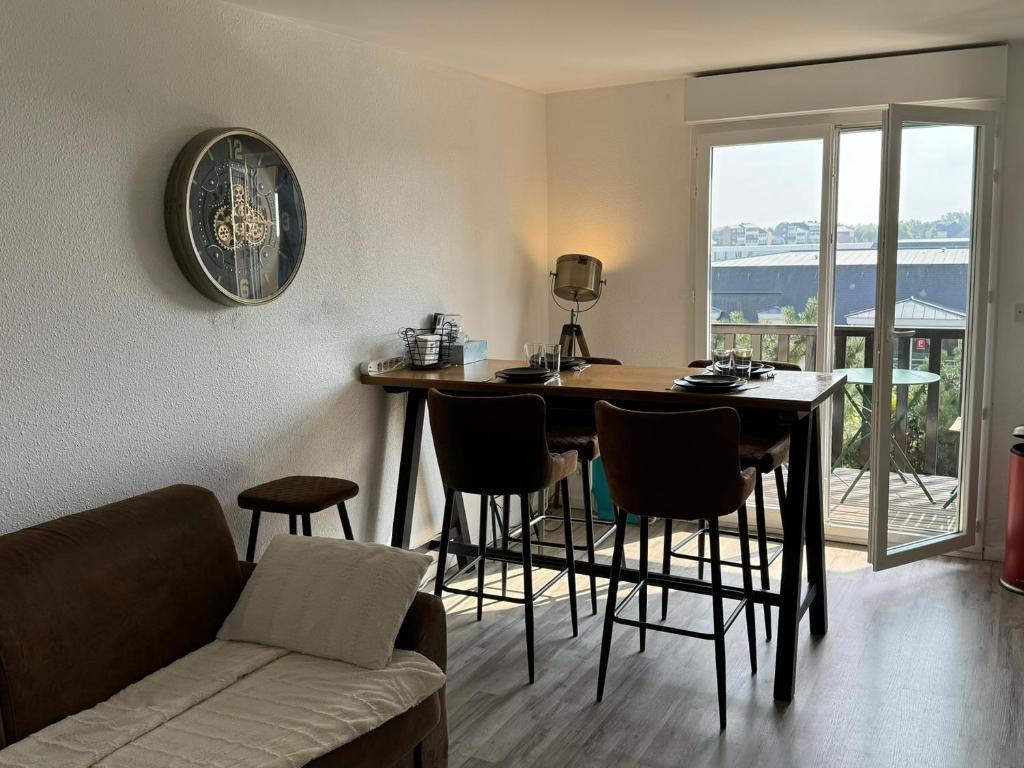 un salon avec une table, des chaises et un canapé dans l'établissement Cabourg: Appartement 2 Pièces, Proche Plage, Balcon, WiFi - FR-1-487-374, à Cabourg