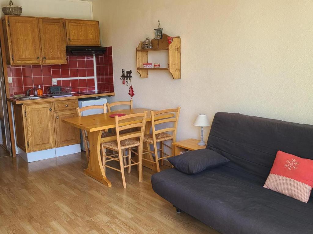un salon avec un canapé et une table et une cuisine dans l'établissement Studio cabine cosy pour 4 au pied des pistes - FR-1-689-140, à Villard-de-Lans