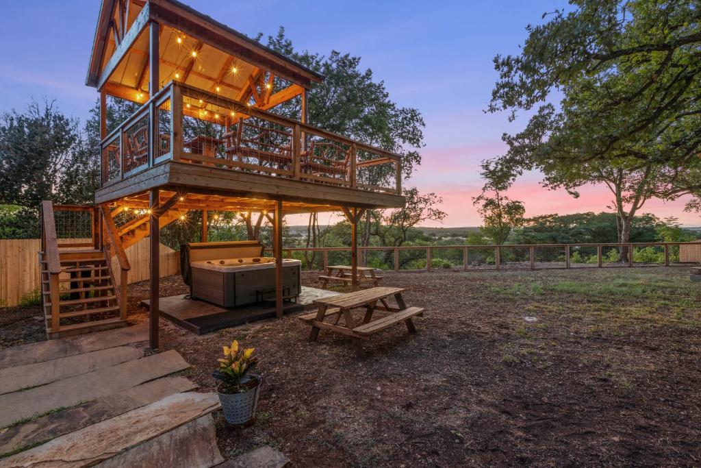 a large tree house with a bench and a table at Guadalupe Bluff Bunk House in Kerrville