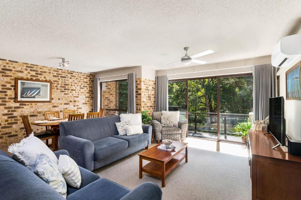 a living room with a blue couch and a tv at Bay Parklands 44 WI FI Netflix Air Con and Views in Nelson Bay