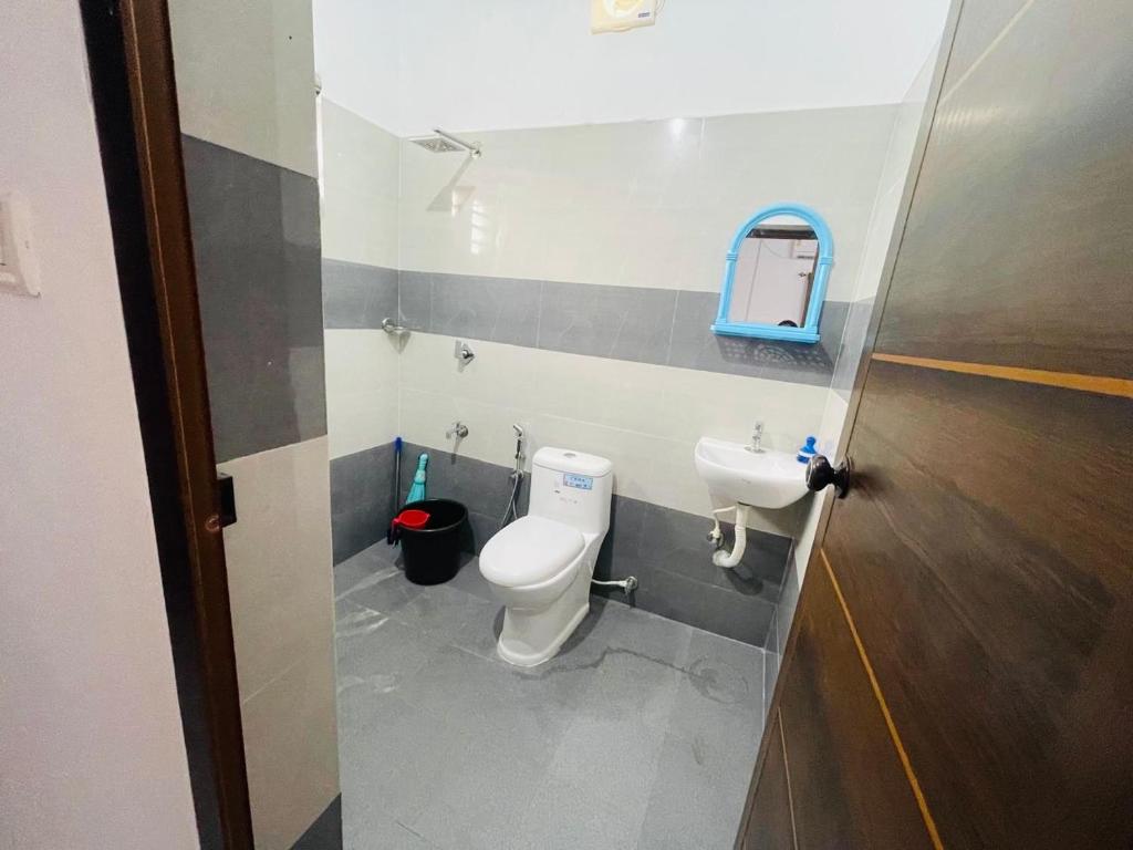 a bathroom with a toilet and a sink at Minty Homestay in Perumanseri