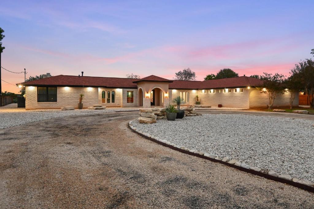 a house with a gravel driveway in front of it at Guadalupe Bluff Mediterranean in Kerrville
