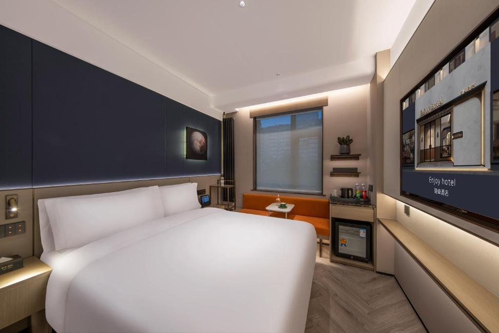 Postel nebo postele na pokoji v ubytování Enjoy Hotel - Provide free late night supplies,free fruit,water and free breakfast coffee,Near Beijing Embassies,Agricultural Exhibition Hall,Sanlitun,Metro line 10 Tuanjiehu,CBD,CCTV,China Zun